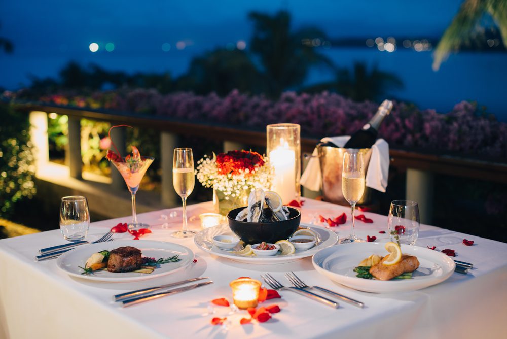Lujosa y romántica mesa de noche a la luz de las velas para pareja en un restaurante con vista al mar
